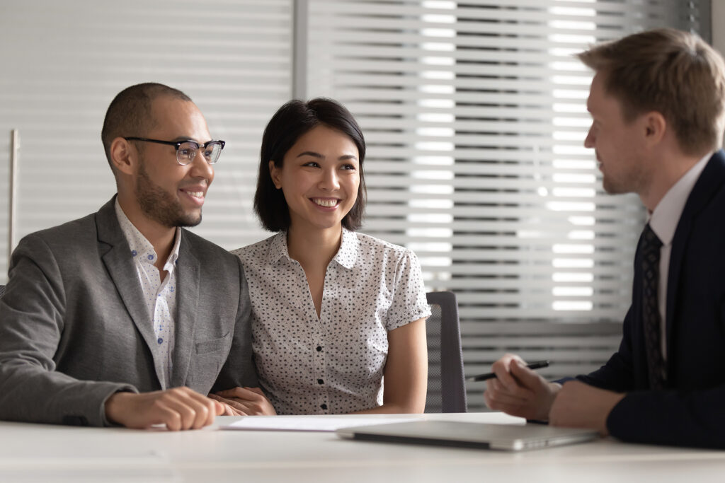 Smiling Couple Meeting with a Trustee Services Administrator in Office